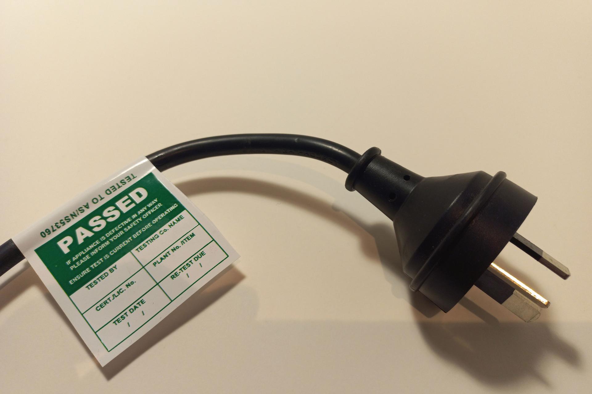 NZ Plug cable with a label tag attached